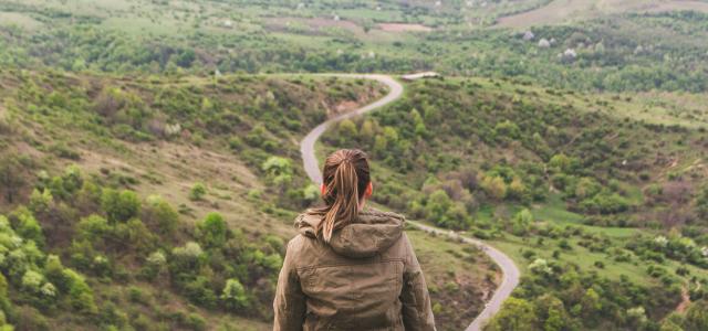 woman sitting on grey cliff by Vlad Bagacian courtesy of Unsplash.